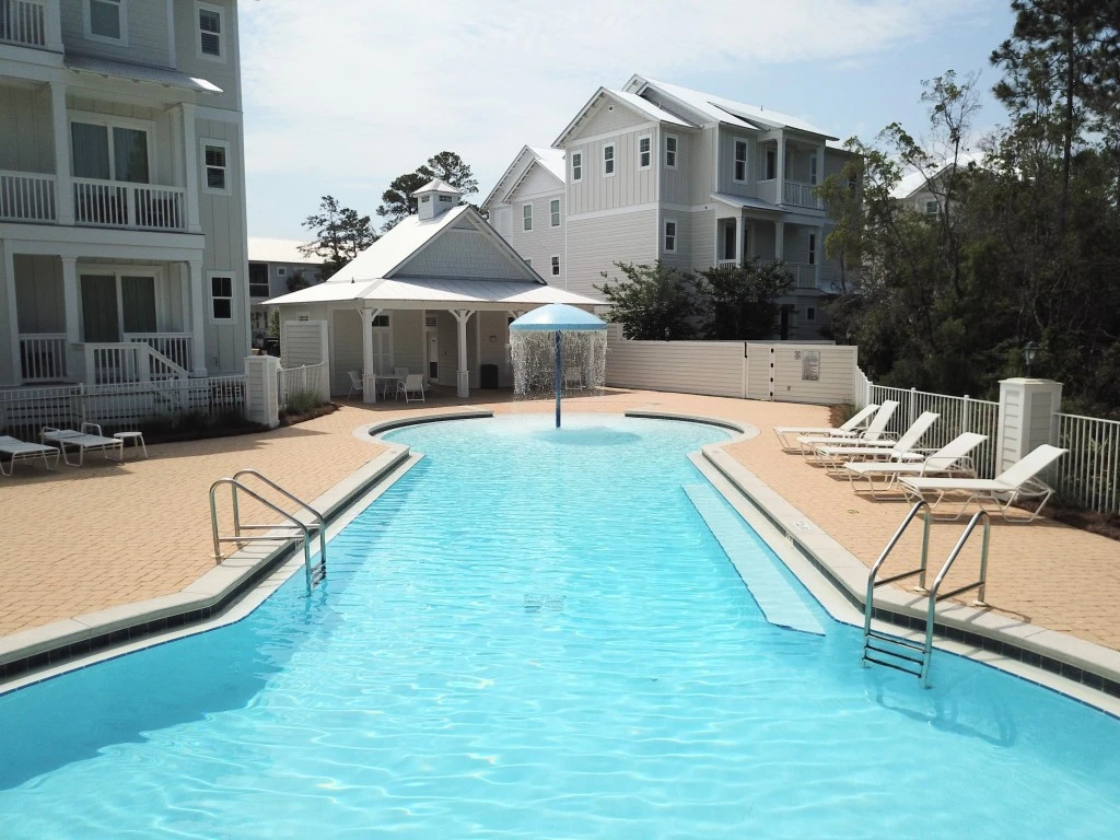 Community pool lined with lounge chairs at The Village at Grayton Beach
